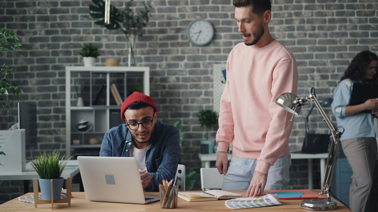 Young professionals collaborating in a modern office space, engaging in a project discussion.